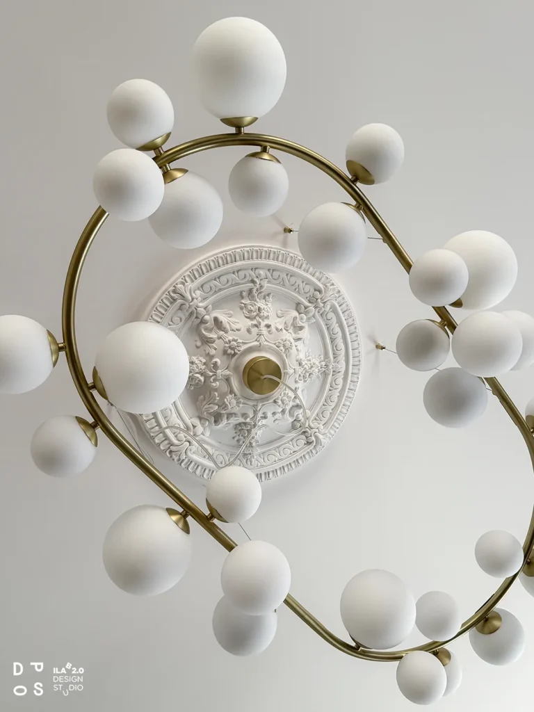 Lampadario a sfere bianche e ottone sotto il rosone in gesso di Casa F+D
