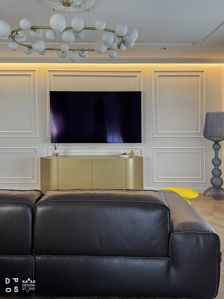 Soggiorno di Casa F+D con divano in pelle e parete tv con boiserie e luce indiretta