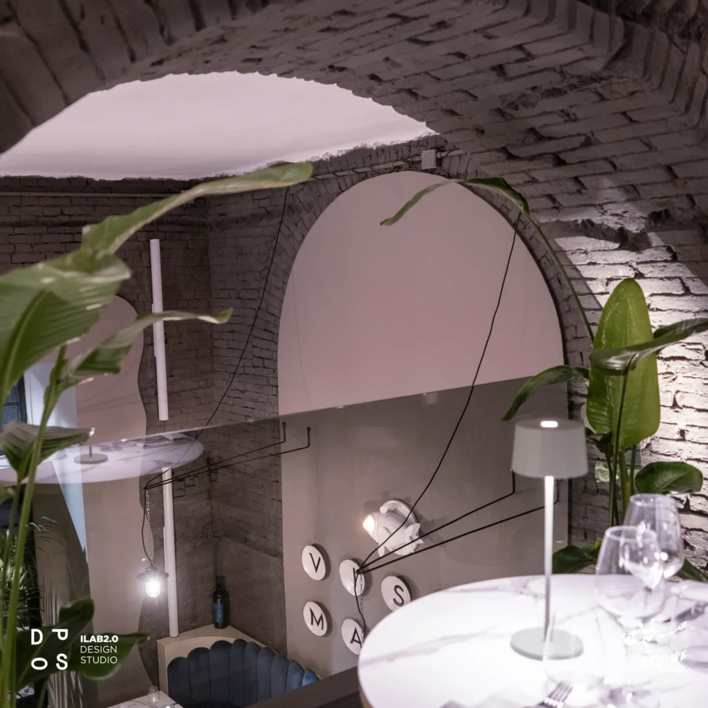 Arco in mattoni con tavolo in marmo e lampada da tavolo a Krudo