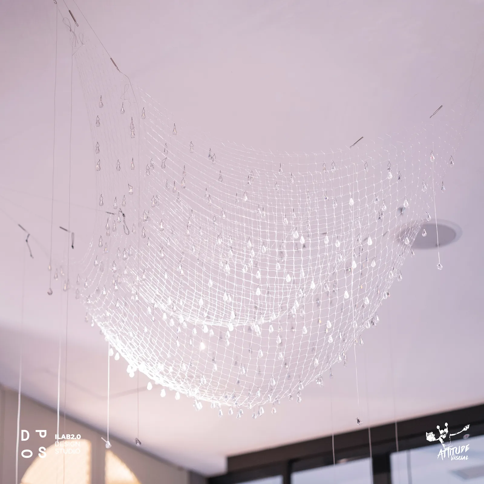 Lampadario a rete da pesca con cristalli sospeso sulla sala di Krudo
