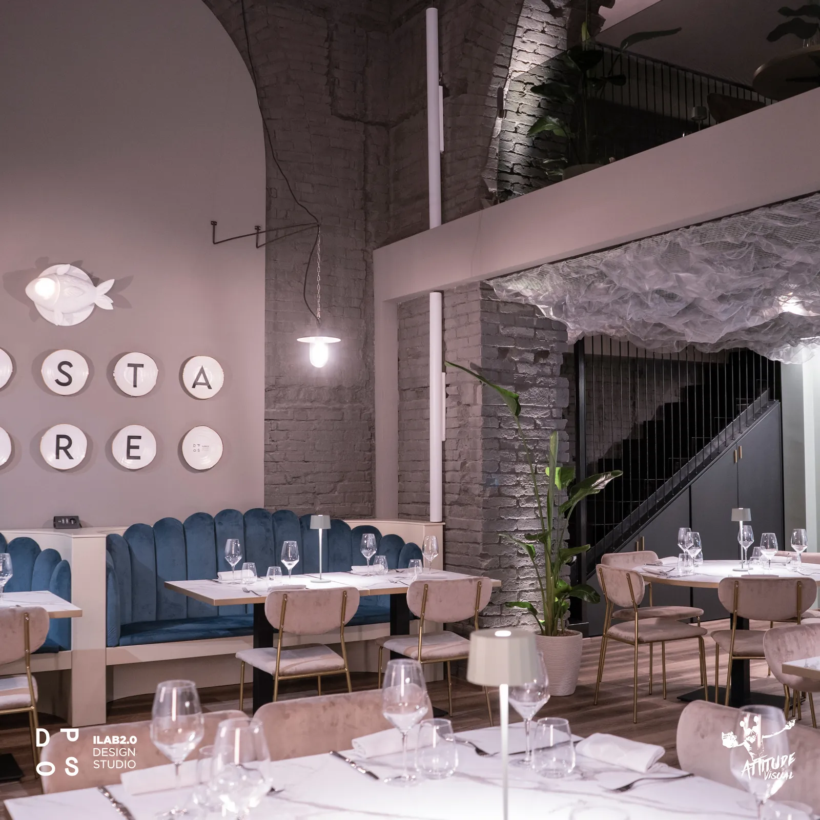 Sala di Krudo con divanetti in velluto blu, soffitto in tulle e scala