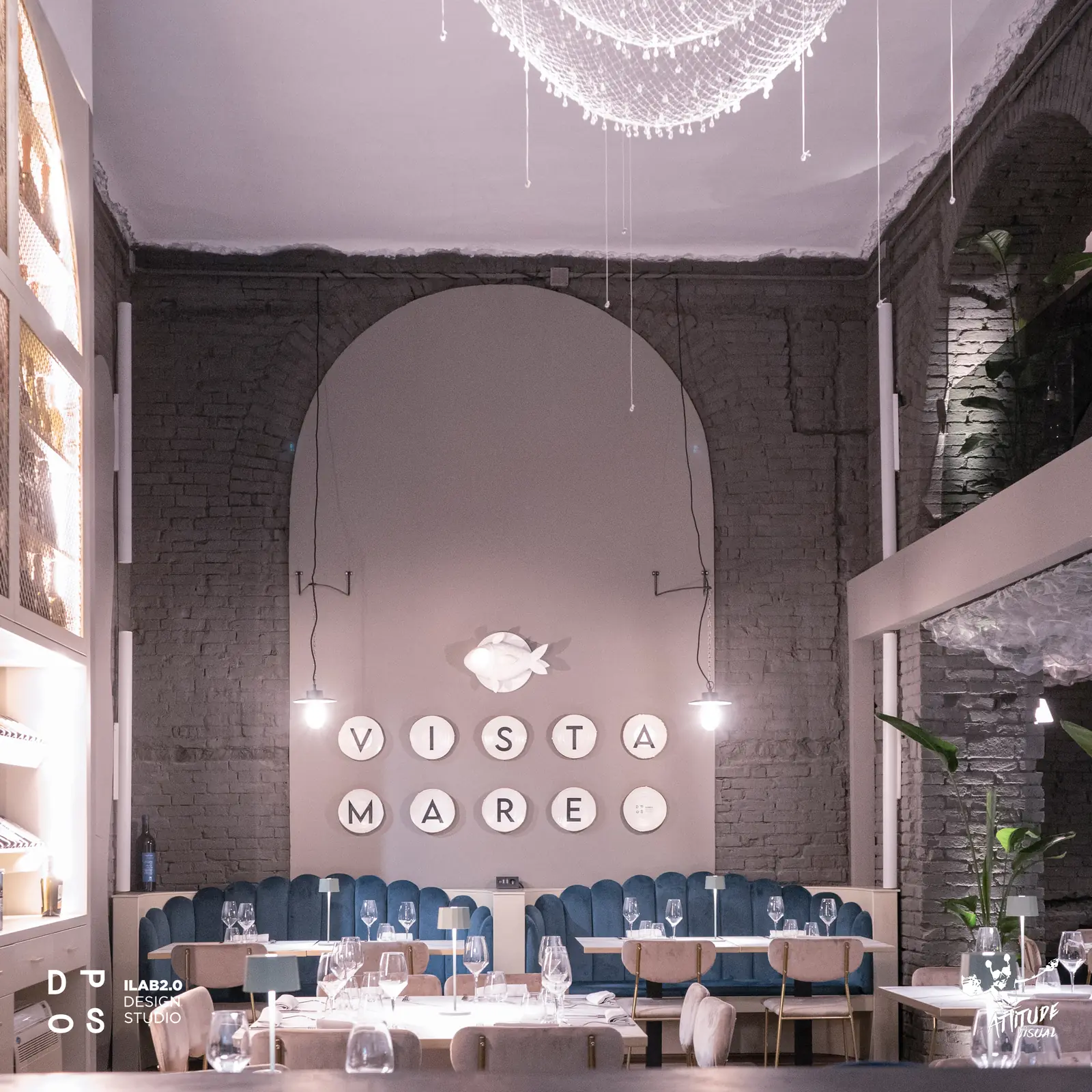 Sala principale di Krudo con l'arco, la parete «Vista mare» e il lampadario a rete