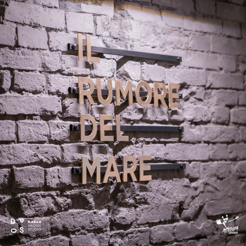 Scritta «Il rumore del mare» sulla parete in mattoni dipinti di Krudo