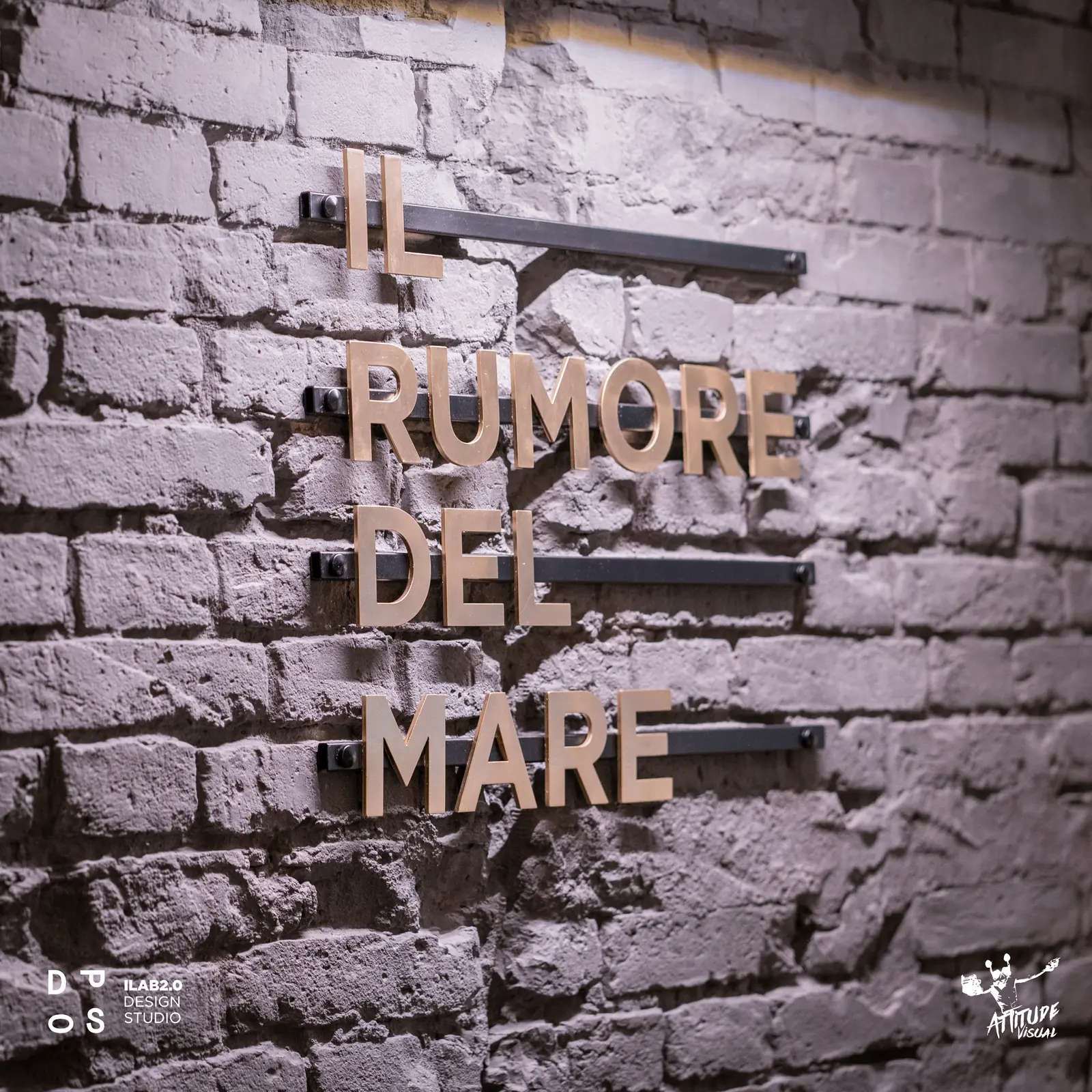 Scritta «Il rumore del mare» sulla parete in mattoni dipinti di Krudo