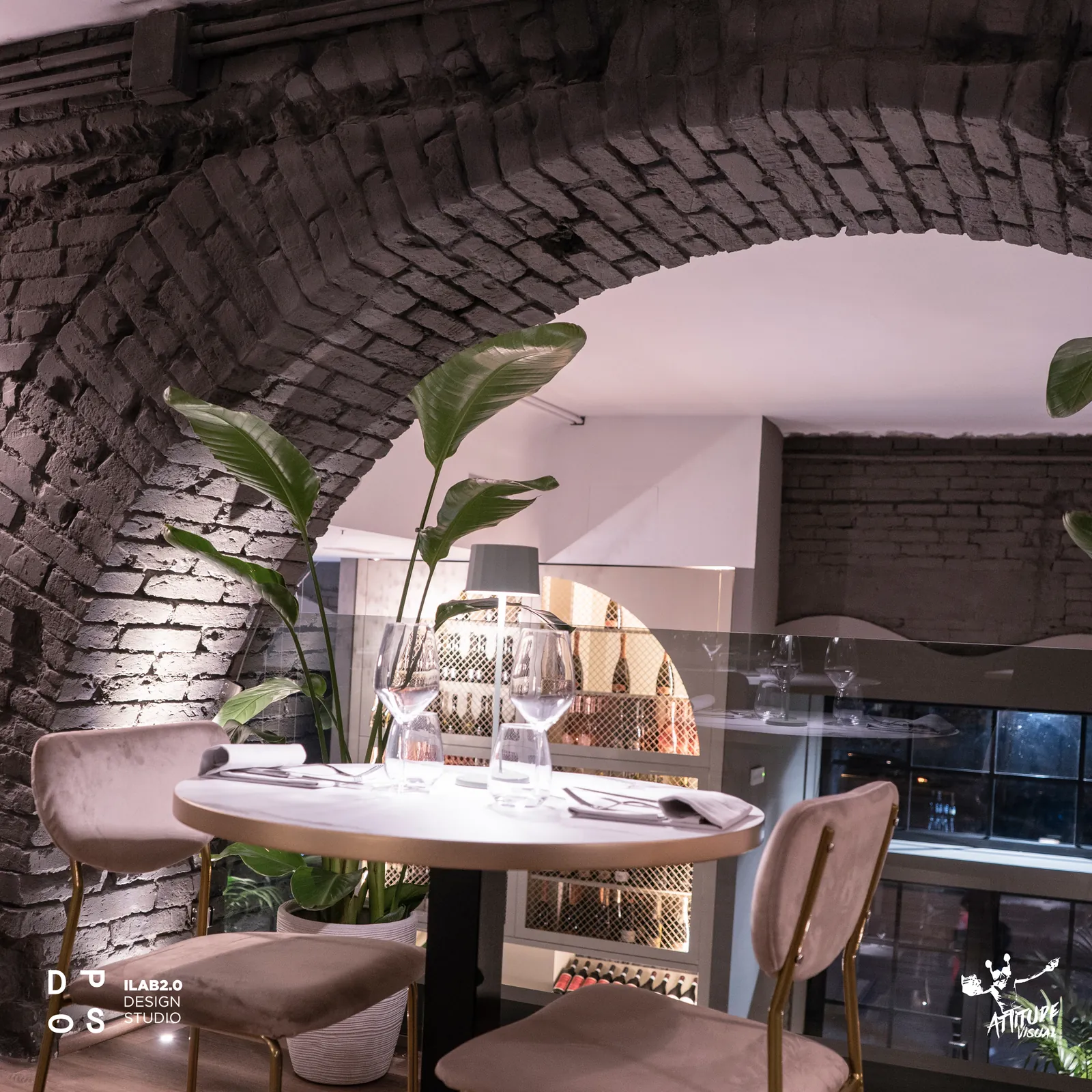 Tavolo rotondo sotto l'arco in mattoni nella sala di Krudo